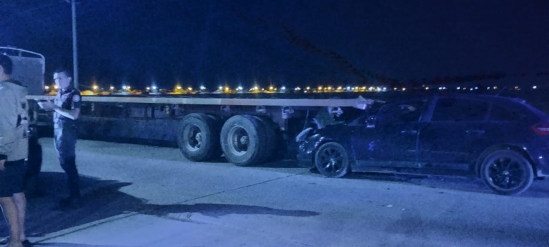 Se incrustó con su auto bajo un camión estacionado