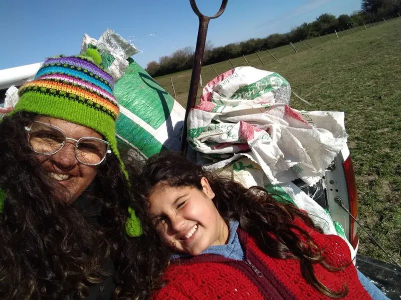 Mariana y su hija, Amparo, cargando la máquina para aplicar fertilizantes
