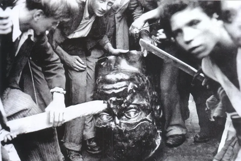 Romanos destruyen una estatua de Mussolini