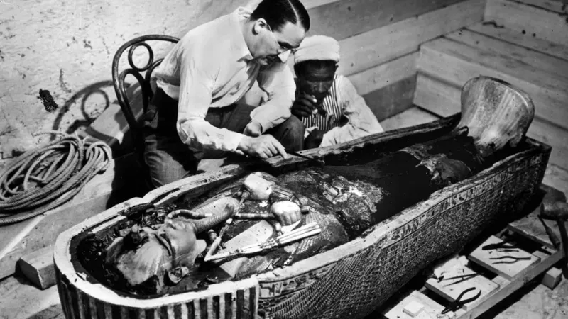 Howard Carter junto a uno de sus múltiples asistentes egipcios examina la momia de Tutankamón