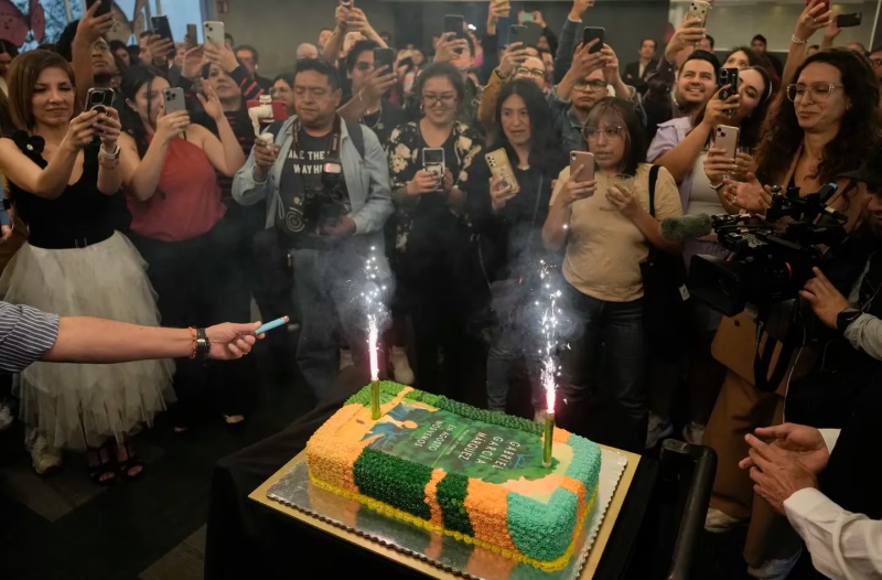 Personas reunidas alrededor de un pastel decorado con la portada de la novela ”En agosto nos vemos” para celebrar el cumpleaños del autor colombiano Gabriel García Márquez y el lanzamiento de su novela póstuma en una librería en la Ciudad de México el mié